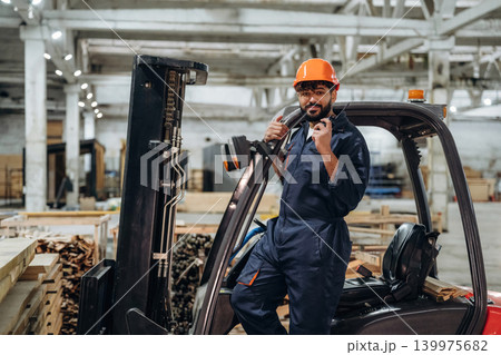 Forklift, machinery to help. Portrait of a male carpenter posing in a woodworking workshop 139975682