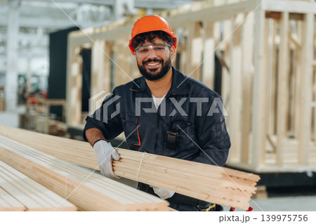 Portrait of a male carpenter posing in a woodworking workshop Portrait of a male carpenter posing in a woodworking workshop 139975756