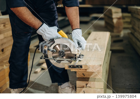 Close-up of a carpenter working with wood using professional tools in a workshop Close-up of a carpenter working with wood using professional tools in a workshop 139975804