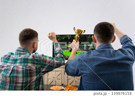 Two fans cheer for their team while watching football Two fans cheer for their team while watching football 139976158