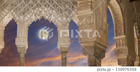 Arches in Islamic (Moorish) style (against the sunset with the super moon) in Alhambra, Granada, Spain Arches in Islamic (Moorish) style (against the sunset with the super moon) in Alhambra, Granada, Spain 139976308