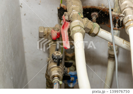 Close-Up Of Plumbing Pipes And Valves Under Sink With White Plastic Tubing And Fittings Close-Up Of Plumbing Pipes And Valves Under Sink With White Plastic Tubing And Fittings 139976750