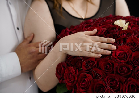 Close up of Woman with Diamond Engagement Ring Holding Large Bouquet of Red Roses Close up of Woman with Diamond Engagement Ring Holding Large Bouquet of Red Roses 139976930