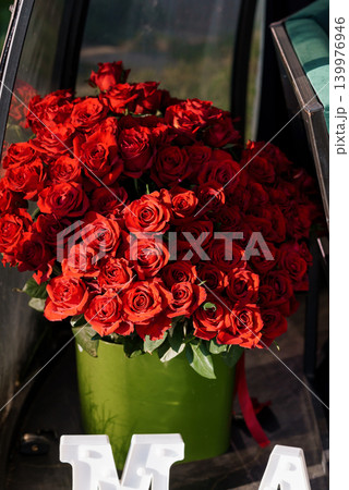 Large Bouquet of Deep Red Roses in a Green Vase for Romantic Celebration and Valentine's Day 139976946