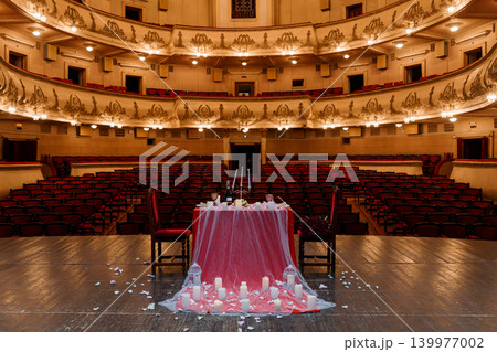 Romantic Wedding Table Setup with Candles and Rose Petals in Grand Vintage Theater Hall Romantic Wedding Table Setup with Candles and Rose Petals in Grand Vintage Theater Hall 139977002