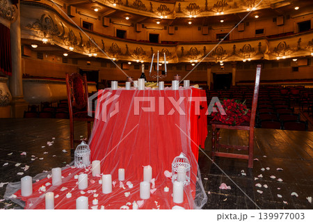 Romantic Red Table Setting with Candles and Roses in Grand Vintage Opera House Theater Romantic Red Table Setting with Candles and Roses in Grand Vintage Opera House Theater 139977003