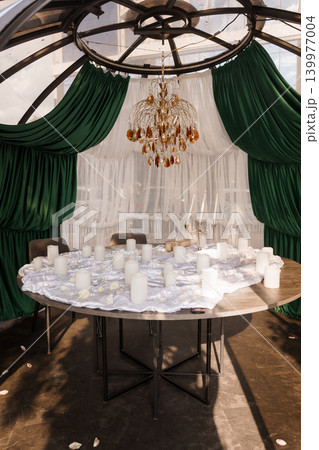 Elegant Wedding Table Setting in Glass Conservatory with Green Curtains and Crystal Chandelier 139977004