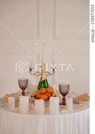 Elegant Champagne Celebration with Candelabra, Oranges and Fruit on White Tablecloth Elegant Champagne Celebration with Candelabra, Oranges and Fruit on White Tablecloth 139977053