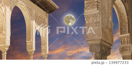 Arches in Islamic (Moorish) style (against the sunset with the super moon) in Alhambra, Granada, Spain Arches in Islamic (Moorish) style (against the sunset with the super moon) in Alhambra, Granada, Spain 139977233