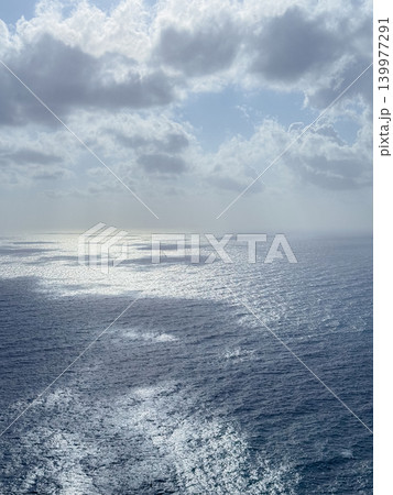 Majestic view of the ocean with the sun reflecting off the water beneath a sky filled with fluffy clouds, creating a serene and breathtaking seascape perfect for relaxation and inspiration Majestic view of the ocean with the sun reflecting off the water beneath a sky filled with fluffy clouds, creating a serene and breathtaking seascape perfect for relaxation and inspiration 139977291