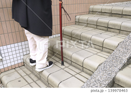 日本の横浜都市景観休みながら、階段を上がる杖の高齢女性。高齢化社会。高齢になるとこの緩い階段すら辛い 日本の横浜都市景観休みながら、階段を上がる杖の高齢女性。高齢化社会。高齢になるとこの緩い階段すら辛い 139978463