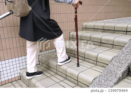 日本の横浜都市景観休みながら、階段を上がる杖の高齢女性。高齢化社会。高齢になるとこの緩い階段すら辛い 139978464