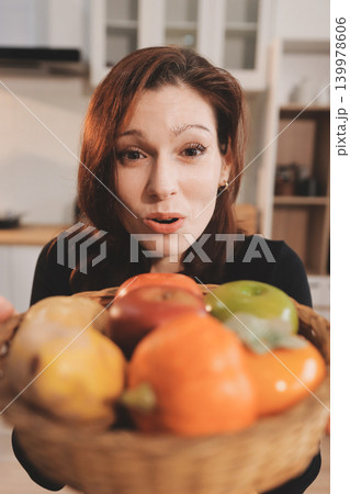 Woman preparing green smoothie in bright kitchen with fresh fruits and vegetables, healthy eating lifestyle moment in natural daylight 139978606