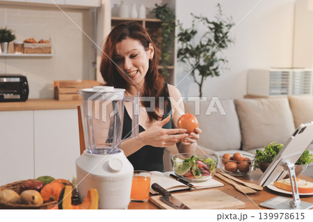 Woman preparing green smoothie in bright kitchen with fresh fruits and vegetables, healthy eating lifestyle moment in natural daylight Woman preparing green smoothie in bright kitchen with fresh fruits and vegetables, healthy eating lifestyle moment in natural daylight 139978615