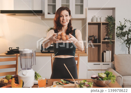 Woman preparing green smoothie in bright kitchen with fresh fruits and vegetables, healthy eating lifestyle moment in natural daylight Woman preparing green smoothie in bright kitchen with fresh fruits and vegetables, healthy eating lifestyle moment in natural daylight 139978622