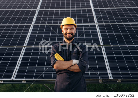 Arms crossed, standing and posing. Male solar engineer examining photovoltaic panels at a power station Arms crossed, standing and posing. Male solar engineer examining photovoltaic panels at a power station 139978852