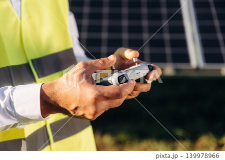 Modern drone conception, control. Male solar engineer examining photovoltaic panels at a power station 139978966