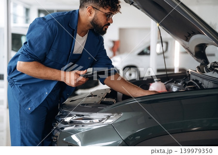 Checking the information. Auto service specialist examining vehicle condition 139979350