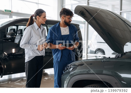 Expertise, explaining the stuff. Technical inspection explained to customer indoors Expertise, explaining the stuff. Technical inspection explained to customer indoors 139979392