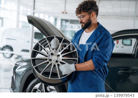 Brand new disk in hands. Auto service specialist examining vehicle condition 139979543