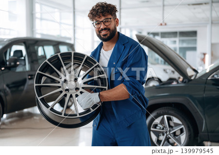 Brand new disk in hands. Auto service specialist examining vehicle condition 139979545