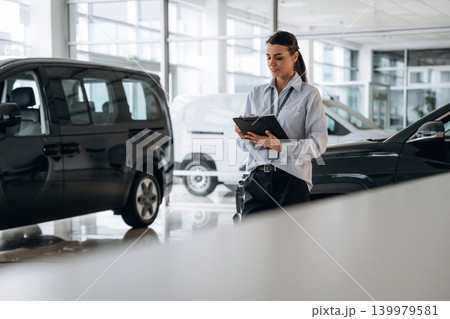 Employee is standing. Successful automotive consultant standing near car interior 139979581
