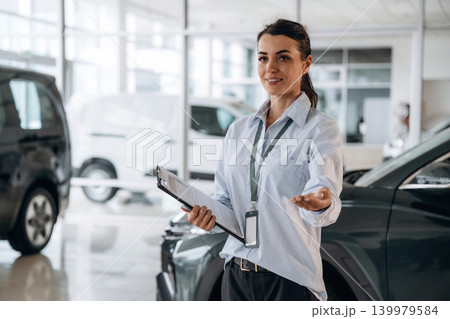 How can I help you conception. Successful automotive consultant standing near car interior How can I help you conception. Successful automotive consultant standing near car interior 139979584