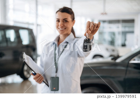 Keys in hand, it can can be yours. Successful automotive consultant standing near car interior Keys in hand, it can can be yours. Successful automotive consultant standing near car interior 139979591