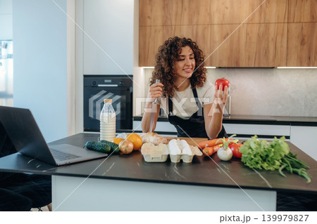 Attractive woman preparing fresh vegetables on the kitchen counter during cooking 139979827