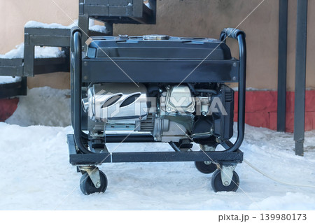 Mobile diesel generator is running outside in winter. Energy independence and electrical equipment. Power supply generator placed in city. 139980173