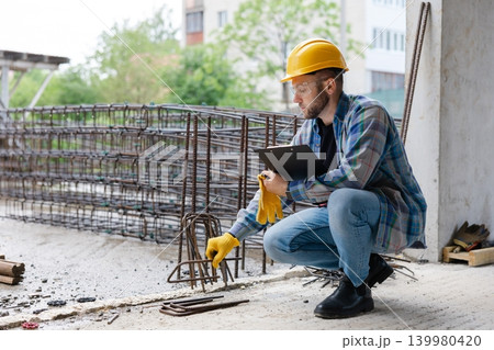 Construction engineer inspecting rebar at building site Construction engineer inspecting rebar at building site 139980420