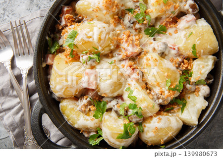New potatoes served with creamy mushroom sauce, bacon and breadcrumbs close-up in a frying pan. Horizontal top view New potatoes served with creamy mushroom sauce, bacon and breadcrumbs close-up in a frying pan. Horizontal top view 139980673