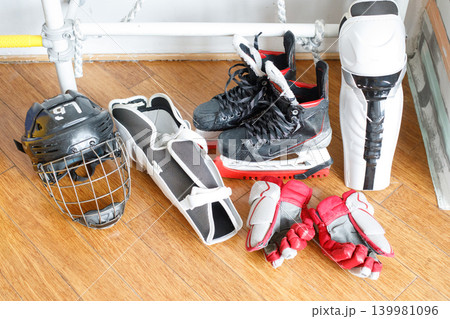 Hockey gear placed on the floor in a training area with various equipment including skates Hockey gear placed on the floor in a training area with various equipment including skates 139981096