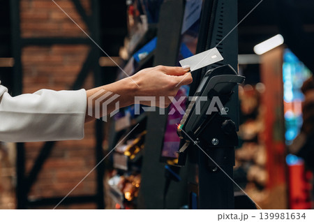 Hand of a customer using a credit card at a payment terminal in a retail store, showcasing modern shopping technology and convenience for consumers Hand of a customer using a credit card at a payment terminal in a retail store, showcasing modern shopping technology and convenience for consumers 139981634