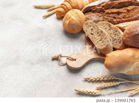 Fresh baked bread assortment with wheat ears on board Fresh baked bread assortment with wheat ears on board 139981763