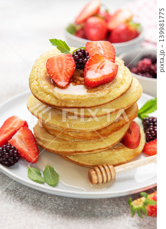 Stack of pancakes with berries, honey, and mint 139981775