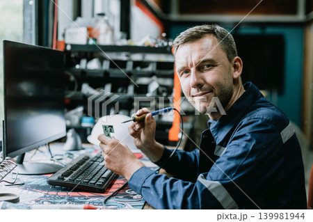 Portrait Electrician male worker happy smile working fix circuit board in workshop with Solder iron Portrait Electrician male worker happy smile working fix circuit board in workshop with Solder iron 139981944