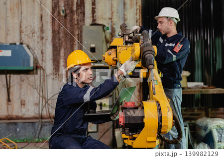 Professional engineer workers team working in metal workshop working together check robot arm welder Professional engineer workers team working in metal workshop working together check robot arm welder 139982129