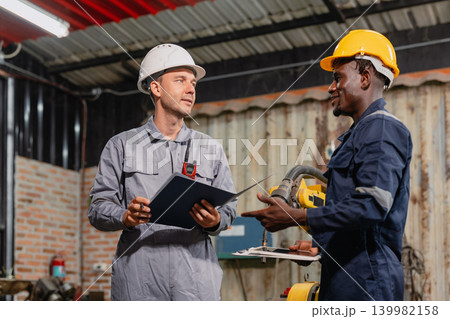 Professional engineer workers team working in metal workshop talking and working together 139982158