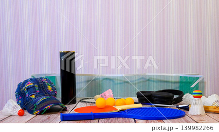 set of various sports equipment for active games on a wooden table near a wall 139982266