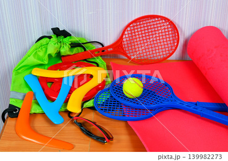 plastic rackets ball and boomerangs on a red sports mat plastic rackets ball and boomerangs on a red sports mat 139982273