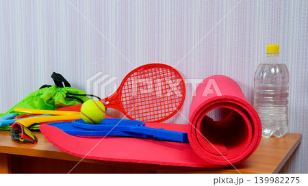 sports items rackets boomerangs and a mat on a wooden table 139982275