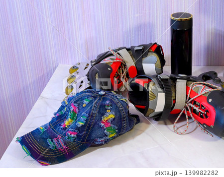 denim cap and red black roller skates with a thermos on a light table denim cap and red black roller skates with a thermos on a light table 139982282