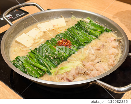 熱々のもつ鍋。牛モツとニラと豆腐が具材の味噌味の鍋料理。 熱々のもつ鍋。牛モツとニラと豆腐が具材の味噌味の鍋料理。 139982826