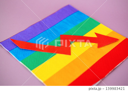 Red upward arrow lies on rainbow flag against purple background. Pink economy growth, LGBTQ market trends, queer spending power, inclusive business expansion. Red upward arrow lies on rainbow flag against purple background. Pink economy growth, LGBTQ market trends, queer spending power, inclusive business expansion. 139983421