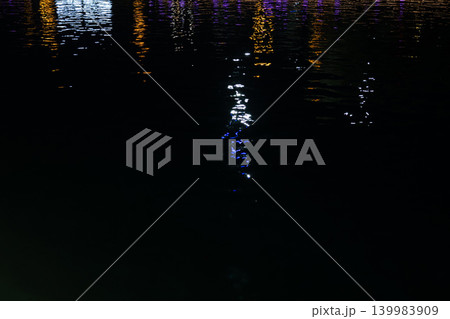 Colorful light reflections on water ripples at night, abstract neon background with copy space. Colorful light reflections on water ripples at night, abstract neon background with copy space. 139983909