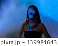 Woman glowing with colorful neon necklace in blue light 139984643