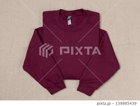 Blank dark red unisex sweatshirt mockup, folded apparel template, copy space on front and sleeves Blank dark red unisex sweatshirt mockup, folded apparel template, copy space on front and sleeves 139985439