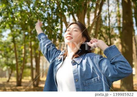 公園で伸びをしてリフレッシュする日本人女性 139985922