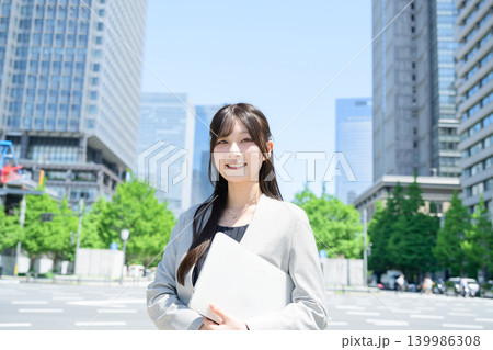 ビル街でノートパソコンを使う日本人女性 139986308